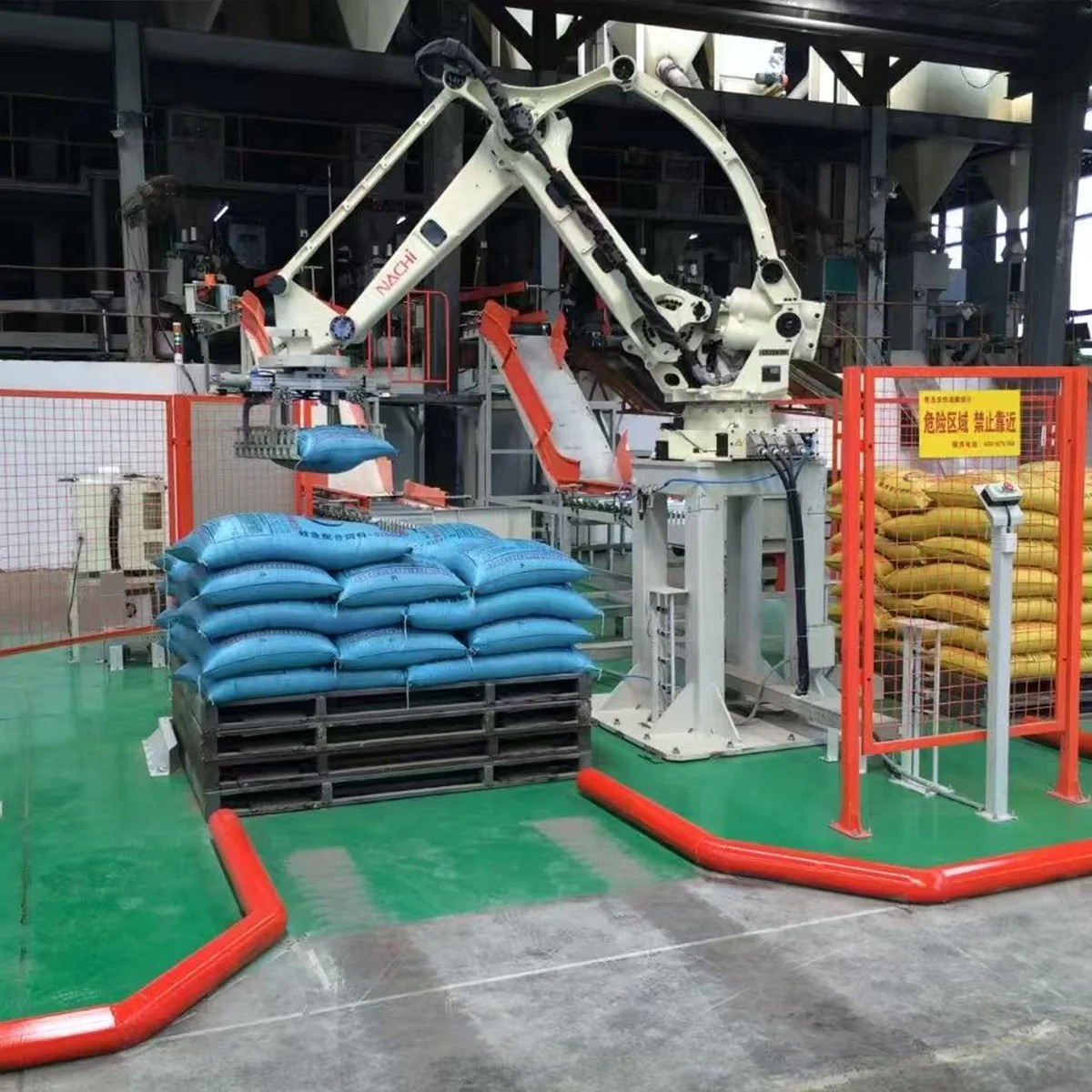 GOJON bag palletizer stacking sacks inside a fenced cell